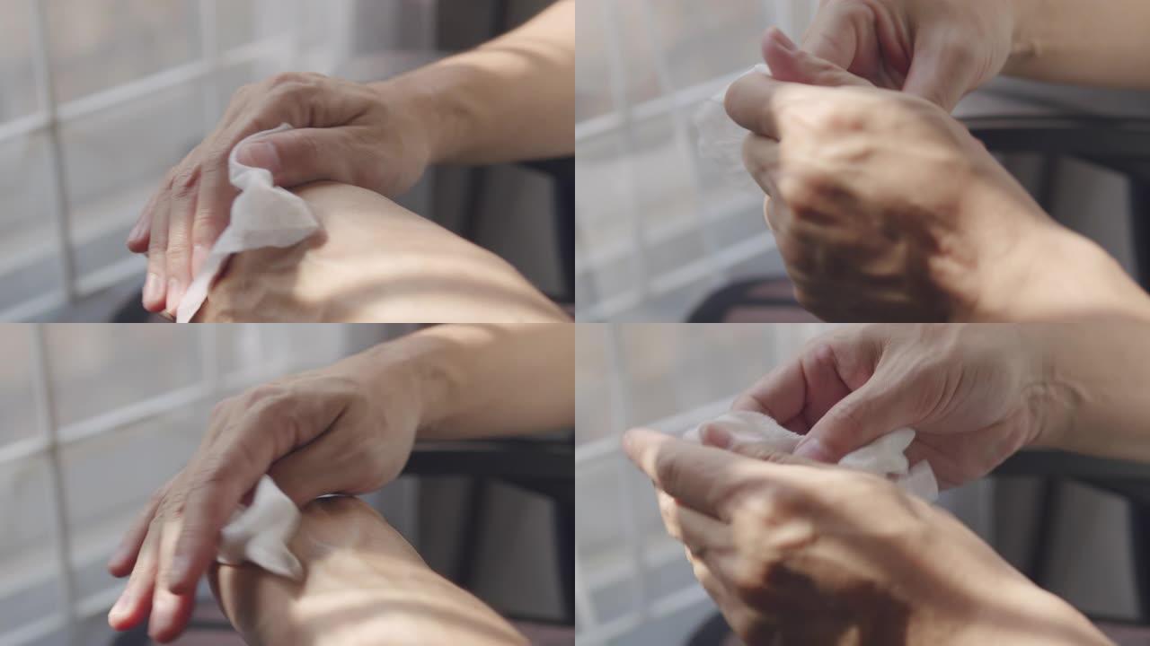 特写亚洲男子用婴儿擦拭纸清洁他肮脏的手。成年男子在家检疫时用白色湿纸巾清理手。具有复制空间的医疗保健