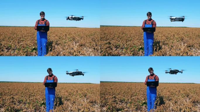 农业学家正在褪色的田野中导航无人机