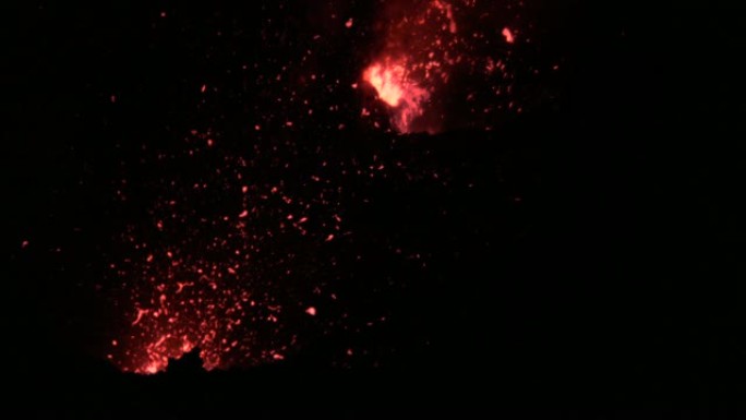 特写: 鲜红色的熔融岩浆碎片从活火山中射出。