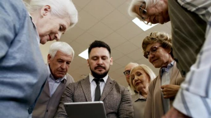 男子教老年人使用平板电脑