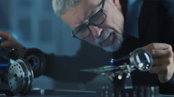 聚焦中年工程师的特写肖像在眼镜中使用高精度激光设备，使用透镜和测试光学器件以获得所需的精度电子设备