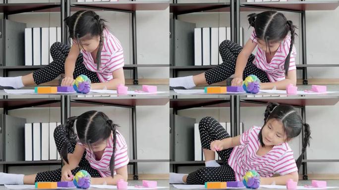 儿童生活中的一天: 微笑的小女孩在家里用橡皮泥做艺术和手工艺。