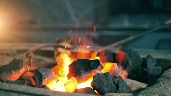铁匠在火上移动煤。