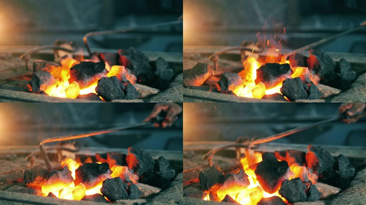 铁匠在火上移动煤。