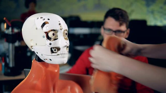 女人把皮肤放在机器人的脸上，特写。