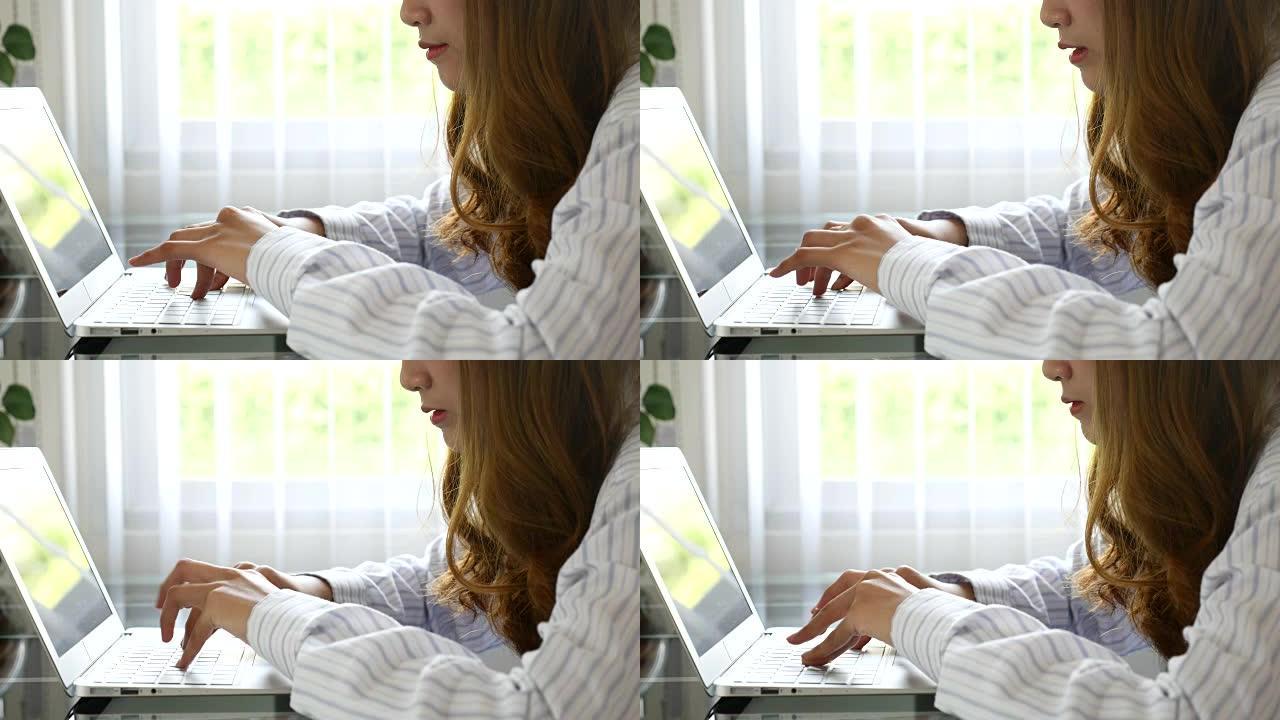 女人在笔记本电脑键盘上打字