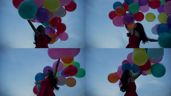 拿着天空背景的气球的女孩在慢动作。