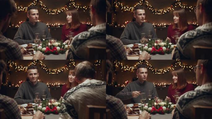 朋友庆祝圣诞节。他们坐在圣诞餐桌旁，在舒适的家庭环境中交流。