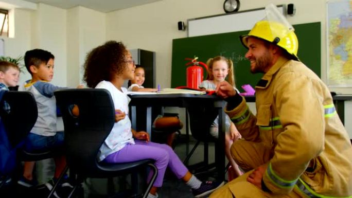 年轻英俊的白人男性消防员在教室4k教女学生消防安全