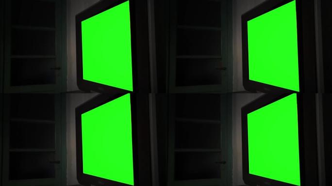 黑暗房间里有绿屏的大平板电视。放大。