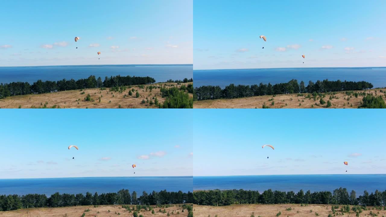 人们带着滑翔伞在天空中飞翔。