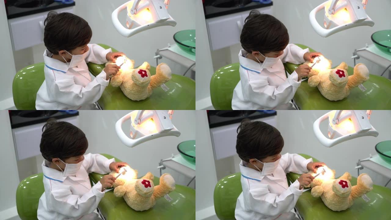 可爱的小男孩假装检查他的泰迪熊牙齿的高角度视图