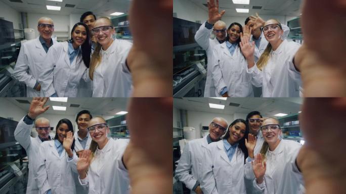 一群戴着防护眼镜的科学家正在对同事进行视频通话或自拍，他们对实验室完成的研究成果感到满意