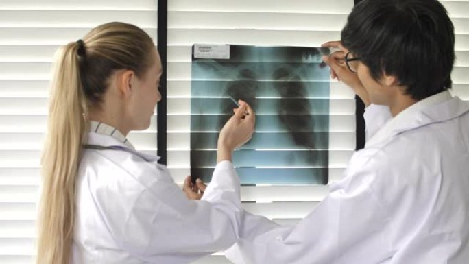两位医生一起检查肺部x射线胶片的讨论