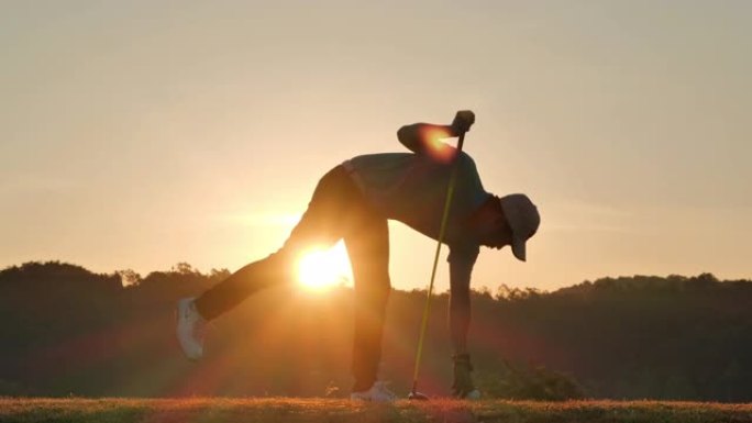 高尔夫球手的剪影在夏天横扫并保持高尔夫球场以放松身心。日落时的剪影高尔夫球手。信心，领导力，力量，技