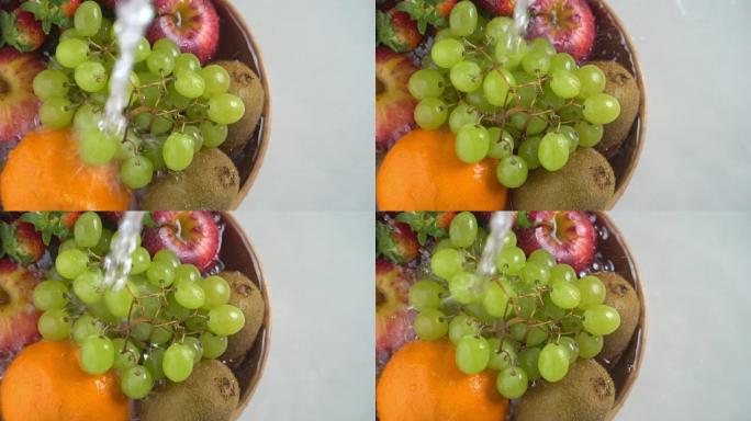 慢动作清洗木碗中的混合水果。