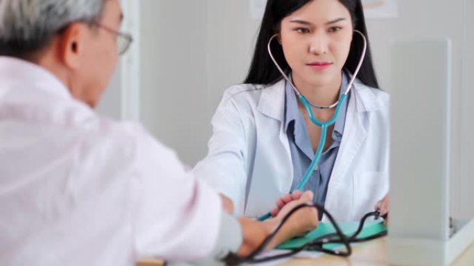 亚洲年轻女性医生在医院检查亚洲老年男性的心脏，以预防冠状病毒或covid19。老年人医疗保健，医疗，