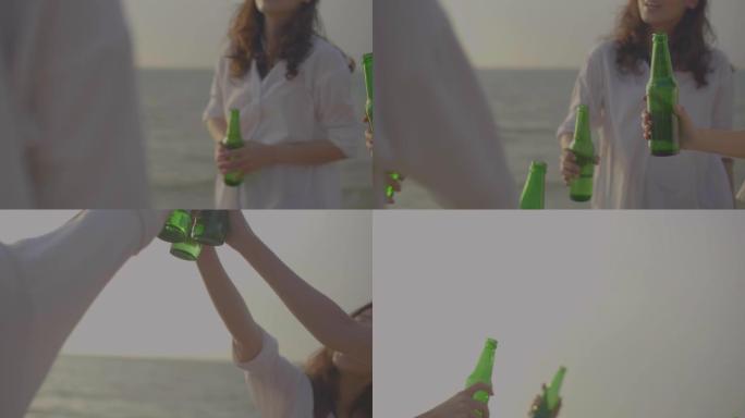 年轻的亚洲成年人在海滩上放松，日落时在海滩上烤啤酒瓶