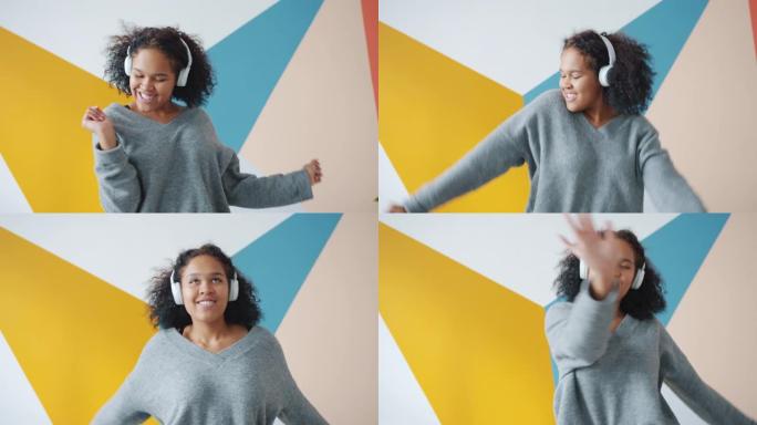 无忧无虑的非洲裔美国女士戴着耳机在室内跳舞的慢动作
