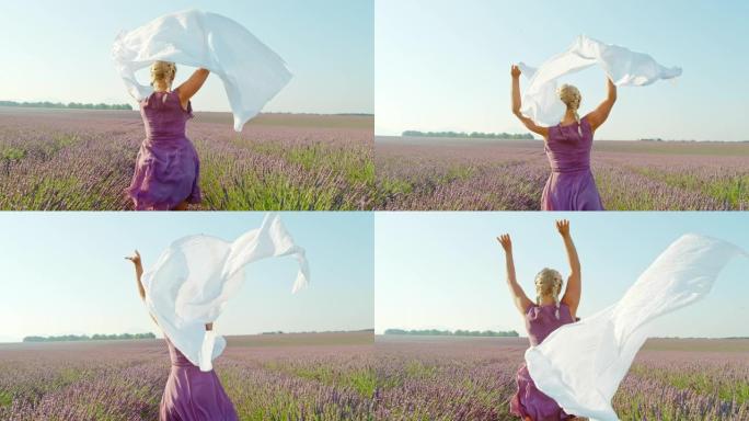 SLO MO女人拿着白色的围巾在薰衣草之间奔跑
