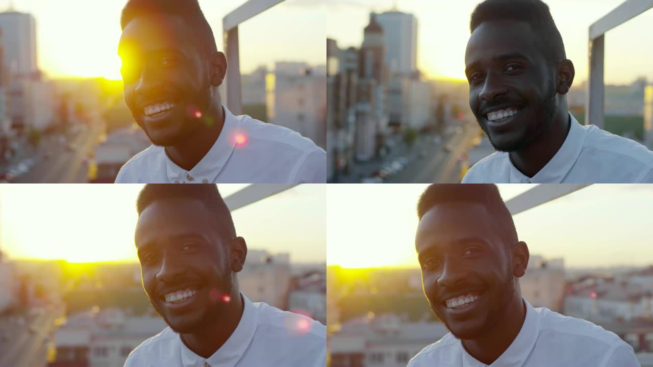 微笑的非洲男子在屋顶上摆姿势拍照