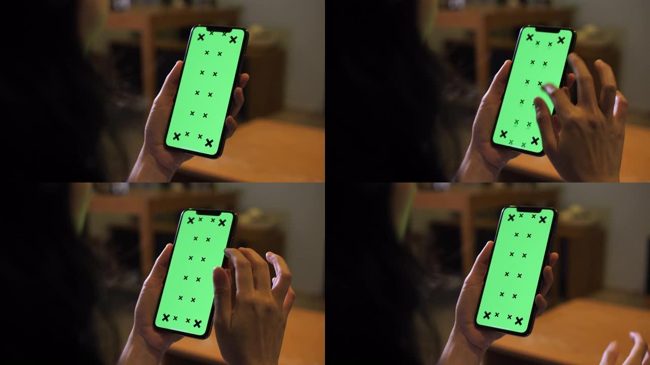 使用绿屏智能手机的特写女人手