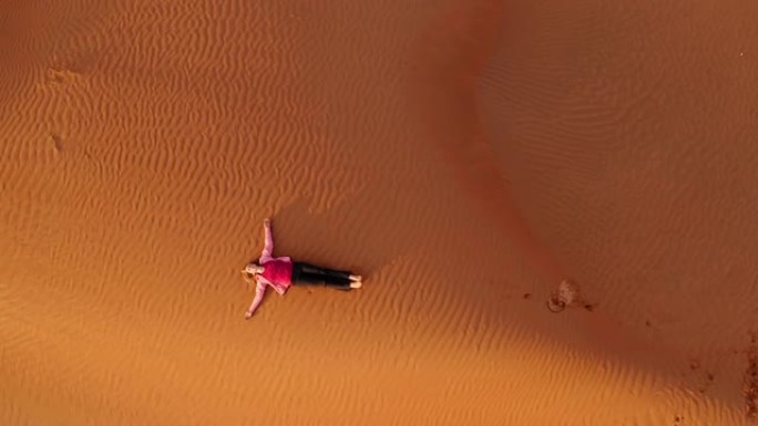 空中女人躺在沙漠中的沙丘上