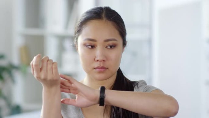 亚洲女性检查脉搏并读取不可见的AR屏幕
