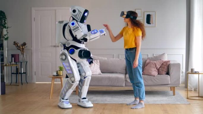 类似人类的机器人正在触摸一位戴着VR眼镜的女士的手。智能家居概念。
