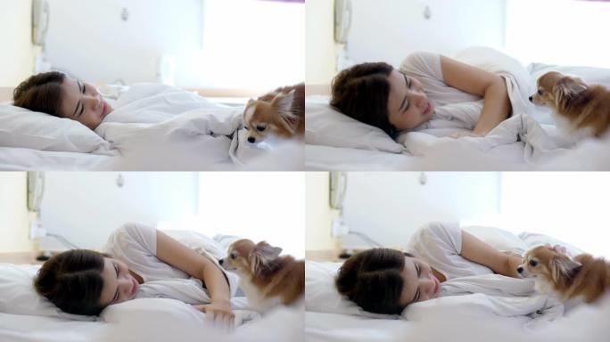 快乐的女人在床上玩她的狗