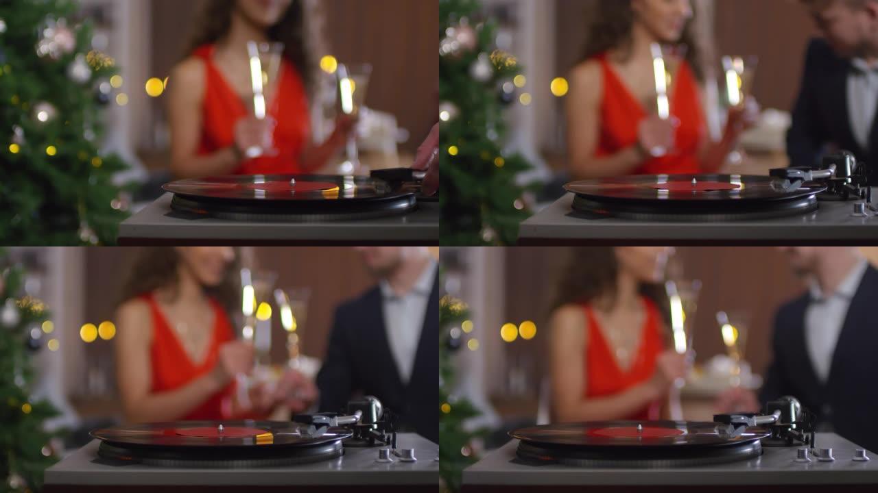 夫妇在圣诞节用香槟听黑胶唱片