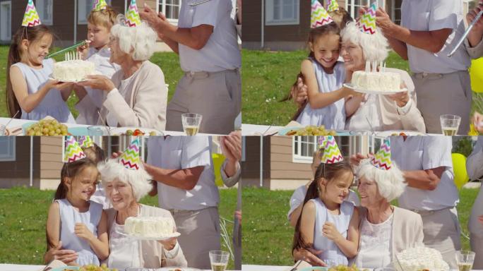 女孩在家庭聚会上给祖母带来生日蛋糕