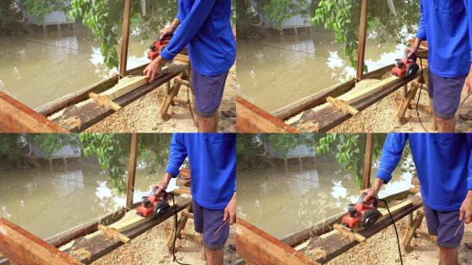 越南东塔丁延亚洲工人用规划机刨削木材的4k镜头，木工工具和机器概念