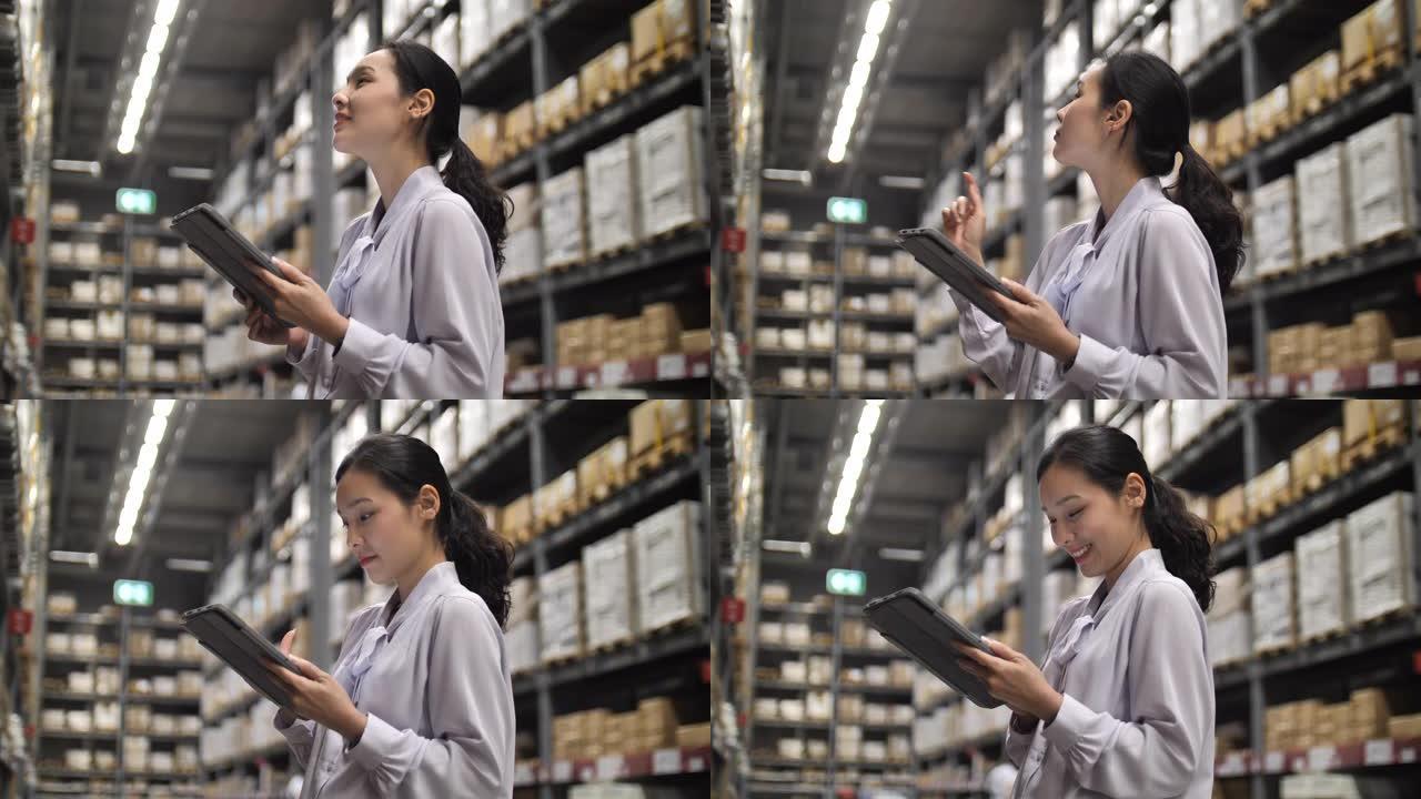 亚洲女商人在仓库中使用数字平板电脑