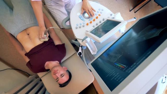 一名成年男子躺在医疗床上并经历超声波的俯视图