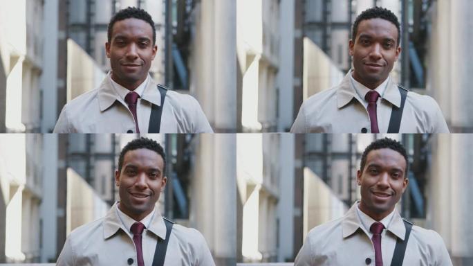 自信的年轻黑人商人站在街上，对镜头微笑，专注于前景，特写镜头