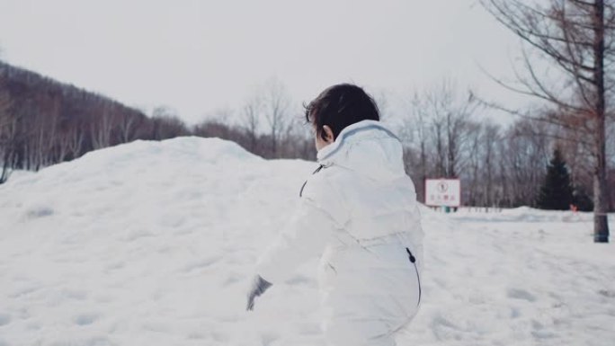 学龄前男孩在雪地里玩耍