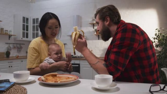 年轻夫妇和他们的孩子一起吃早餐