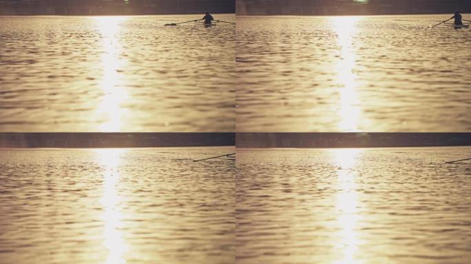 日落期间，男子在河上划桨船