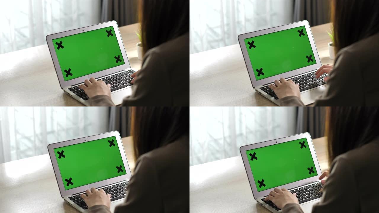 女人用绿屏显示器在笔记本电脑键盘上打字
