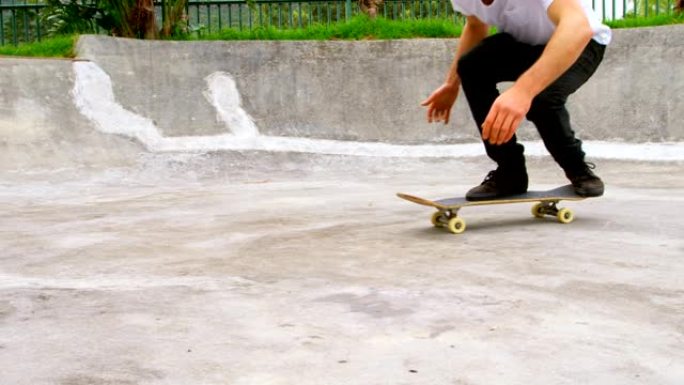 在滑板公园4k的坡道上练习滑板技巧的年轻人的低段