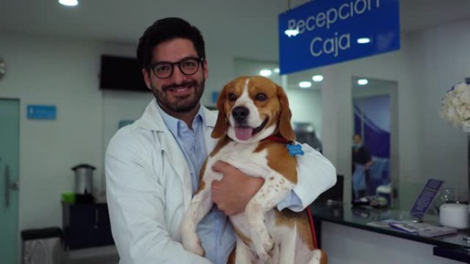 快乐的兽医在诊所里带着一只比格犬，看着相机微笑