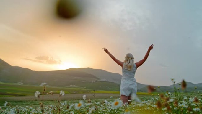 WS超级慢动作无忧无虑的年轻女子在意大利翁布里亚城堡日出时在田园诗般的草地上奔跑