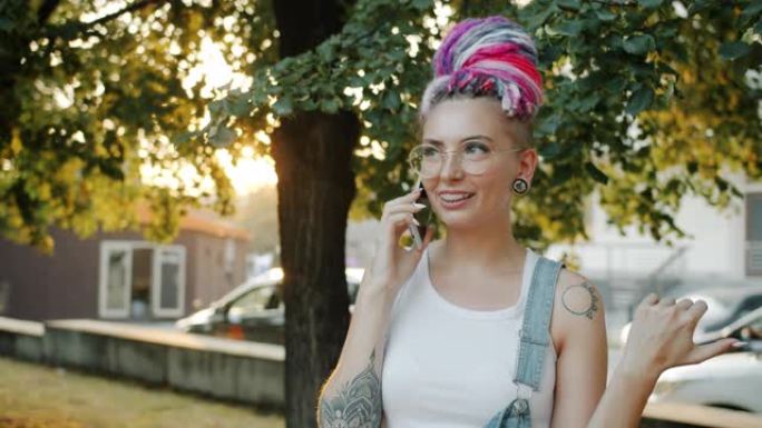 城市公园里有纹身和五颜六色头发的女孩在手机上聊天