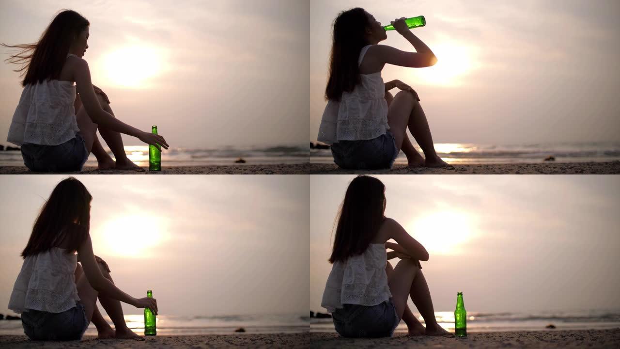 悲伤的女人在日落的海滩上喝酒