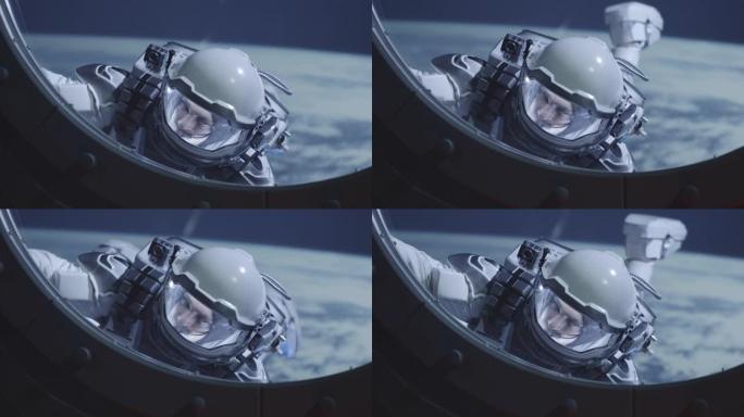 宇航员在航天器窗户上漂浮