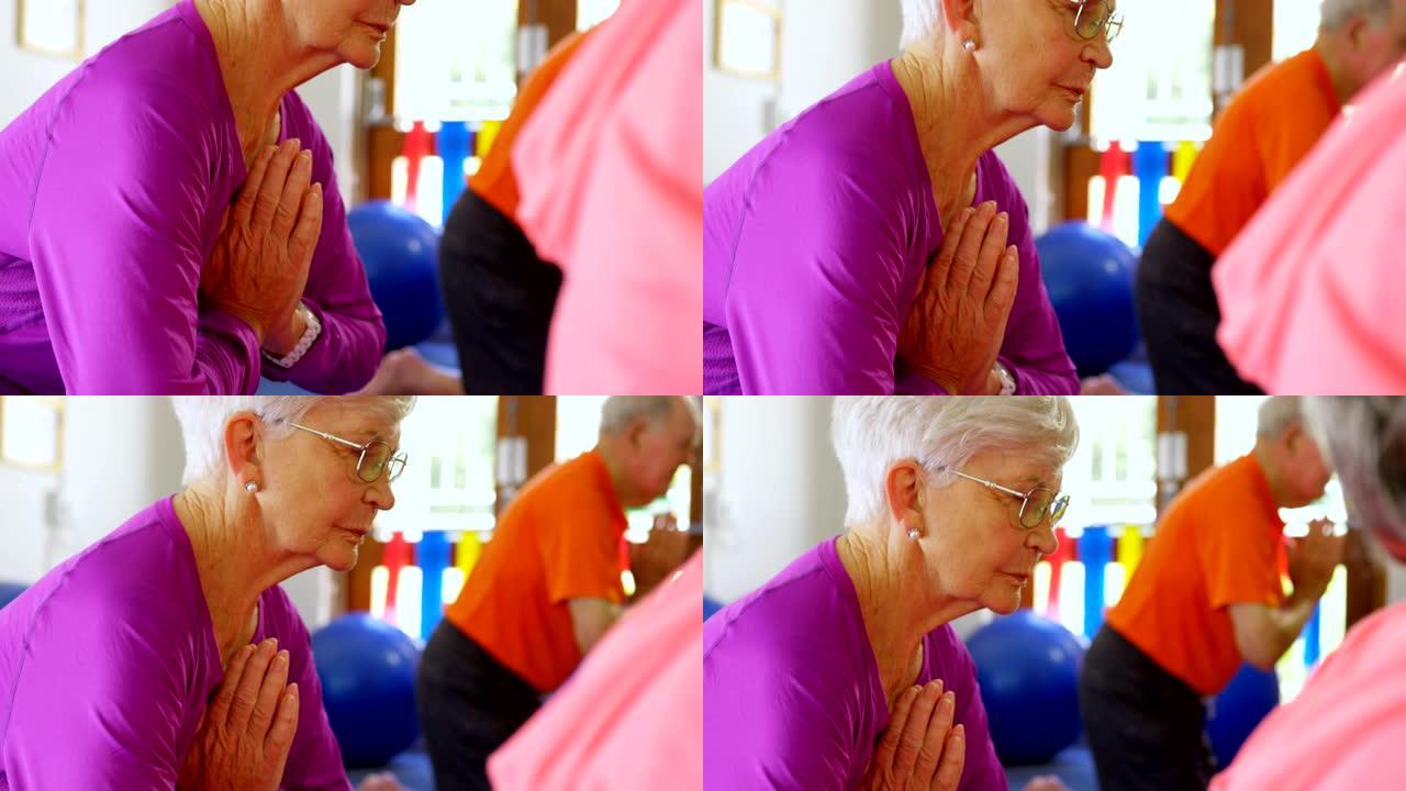 活跃的混血老年人在健身室4k表演瑜伽的侧视图