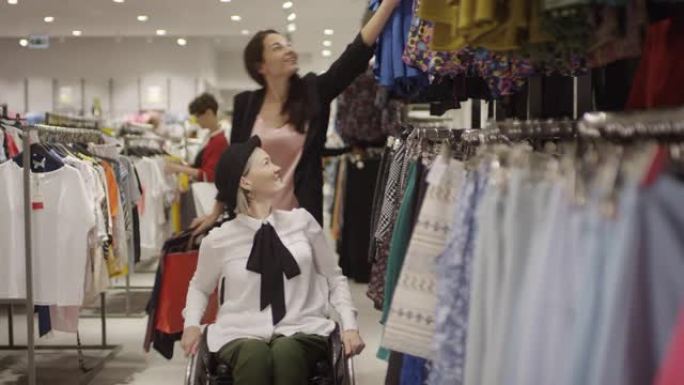 坐在轮椅上的女人和朋友一起买衣服