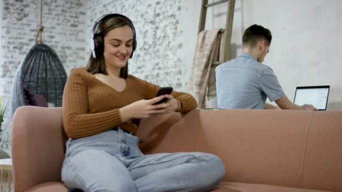 千禧一代女性在手机上发短信并听音乐