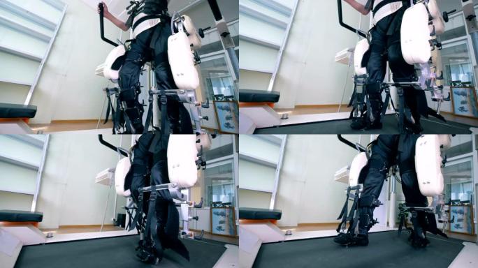 患有身体障碍的男性患者正在步行轨道模拟器上锻炼。康复用电子医疗机器人。